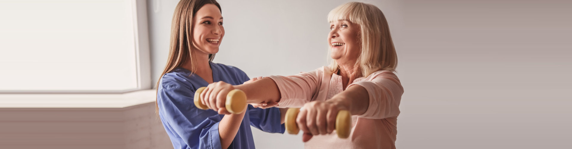 female caregiver and her old woman patient doing exercise